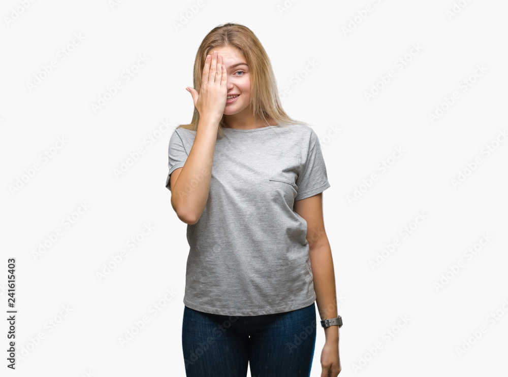 Young caucasian woman over isolated background covering one eye with hand with confident smile on face and surprise emotion. Young caucasian woman over isolated background covering one eye with hand with confident smile on face and surprise emotion.