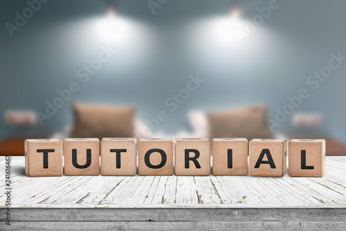Tutorial sign on a wooden table in a room with lights