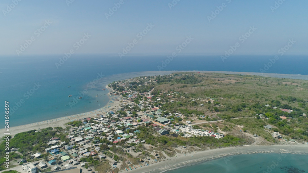 Tropical island with sandy beach, palm trees. Aerial view of coast island Pinget with colorful reef. Seascape, ocean and beautiful beach. Philippines, Luzon. Travel concept.