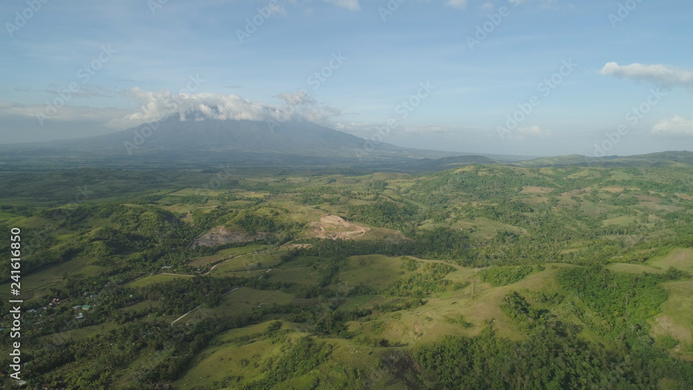 Fototapeta premium Aerial view of mountain valley with hillscovered forest, trees, mount Iriga. Luzon, Philippines. Slopes of mountains with evergreen vegetation. Mountainous tropical landscape.