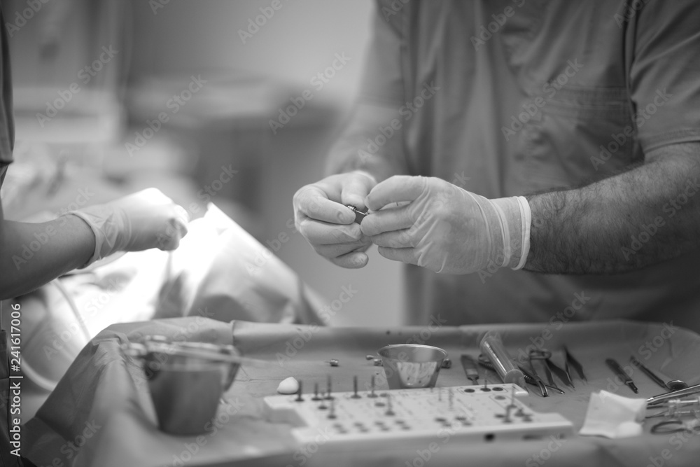 Doctor's hands with the instrument in the operating room of the dental clinic
