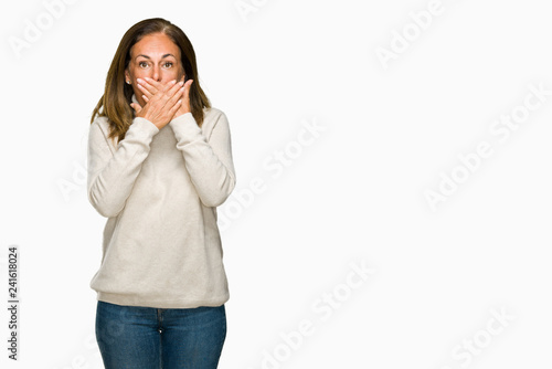 Beautiful middle age adult woman wearing winter sweater over isolated background shocked covering mouth with hands for mistake. Secret concept. © Krakenimages.com
