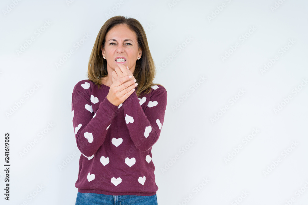 Beautiful middle age woman wearing heart sweater over isolated background Suffering pain on hands and fingers, arthritis inflammation Beautiful middle age woman wearing heart sweater over isolated background Suffering pain on hands and fingers, arthritis inflammation