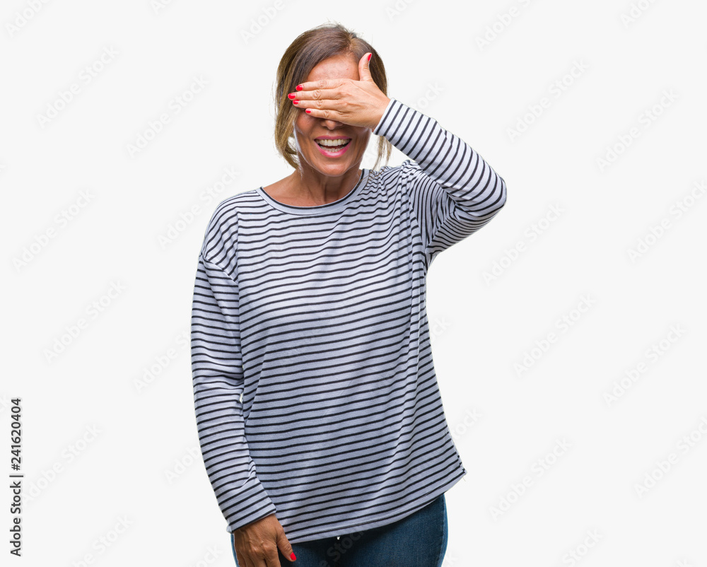 Middle age senior hispanic woman over isolated background smiling and laughing with hand on face covering eyes for surprise. Blind concept. Middle age senior hispanic woman over isolated background smiling and laughing with hand on face covering eyes for surprise. Blind concept.