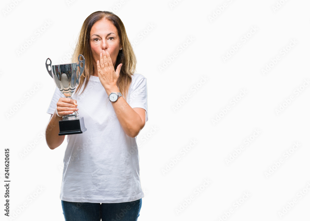Middle age hispanic winner woman celebrating award holding trophy over isolated background cover mouth with hand shocked with shame for mistake, expression of fear, scared in silence, secret concept Middle age hispanic winner woman celebrating award holding trophy over isolated background cover mouth with hand shocked with shame for mistake, expression of fear, scared in silence, secret concept
