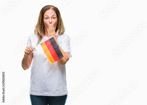Middle age hispanic woman holding flag of Germany over isolated background cover mouth with hand shocked with shame for mistake, expression of fear, scared in silence, secret concept