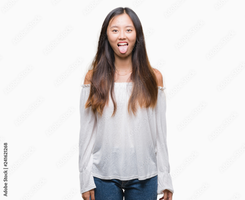 Obraz premium Young asian woman over isolated background sticking tongue out happy with funny expression. Emotion concept.