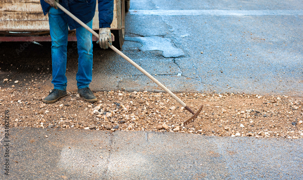worker committed to the repair of a large pit road with inert mixed stabilized worker committed to the repair of a large pit road with inert mixed stabilized