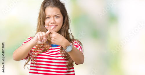 Young beautiful brunette woman wearing stripes t-shirt over isolated background Rejection expression crossing fingers doing negative sign