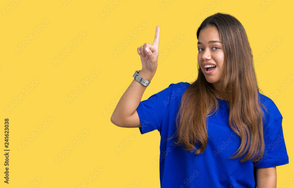 Young beautiful brunette woman wearing blue t-shirt over isolated background pointing finger up with successful idea. Exited and happy. Number one. Young beautiful brunette woman wearing blue t-shirt over isolated background pointing finger up with successful idea. Exited and happy. Number one.