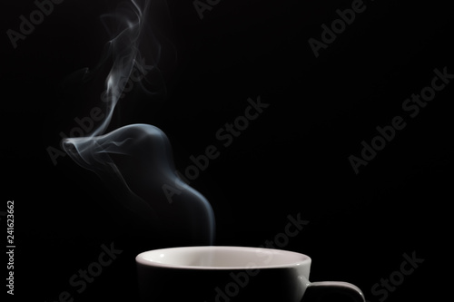 Fragrant coffee on a black background for your advertising. Smoke from hot coffee.