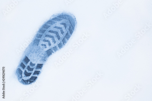 one left foot shoe print on snow, top view, copy space, cloudy a