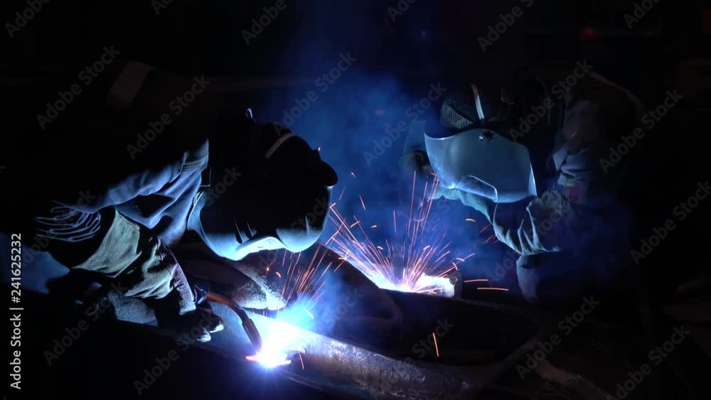 Welders welding metalwork in a factory Welders welding metalwork in a factory