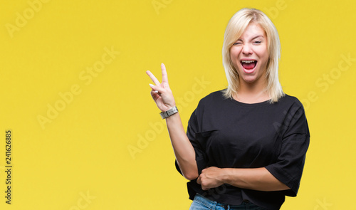Young beautiful blonde woman over isolated background smiling with happy face winking at the camera doing victory sign. Number two.