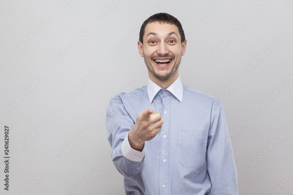 Is that was you? Amazed handsome bristle businessman in classic blue shirt standing, pointing and looking at camera with surprised face. indoor studio shot, isolated on grey background copyspace. Is that was you? Amazed handsome bristle businessman in classic blue shirt standing, pointing and looking at camera with surprised face. indoor studio shot, isolated on grey background copyspace.