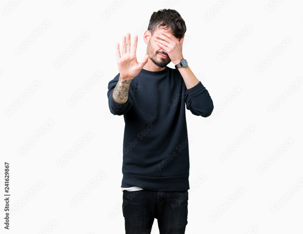 Young handsome man over isolated background covering eyes with hands and doing stop gesture with sad and fear expression. Embarrassed and negative concept. Young handsome man over isolated background covering eyes with hands and doing stop gesture with sad and fear expression. Embarrassed and negative concept.