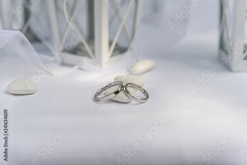 Close up of Wedding rings near comfits and wedding favors