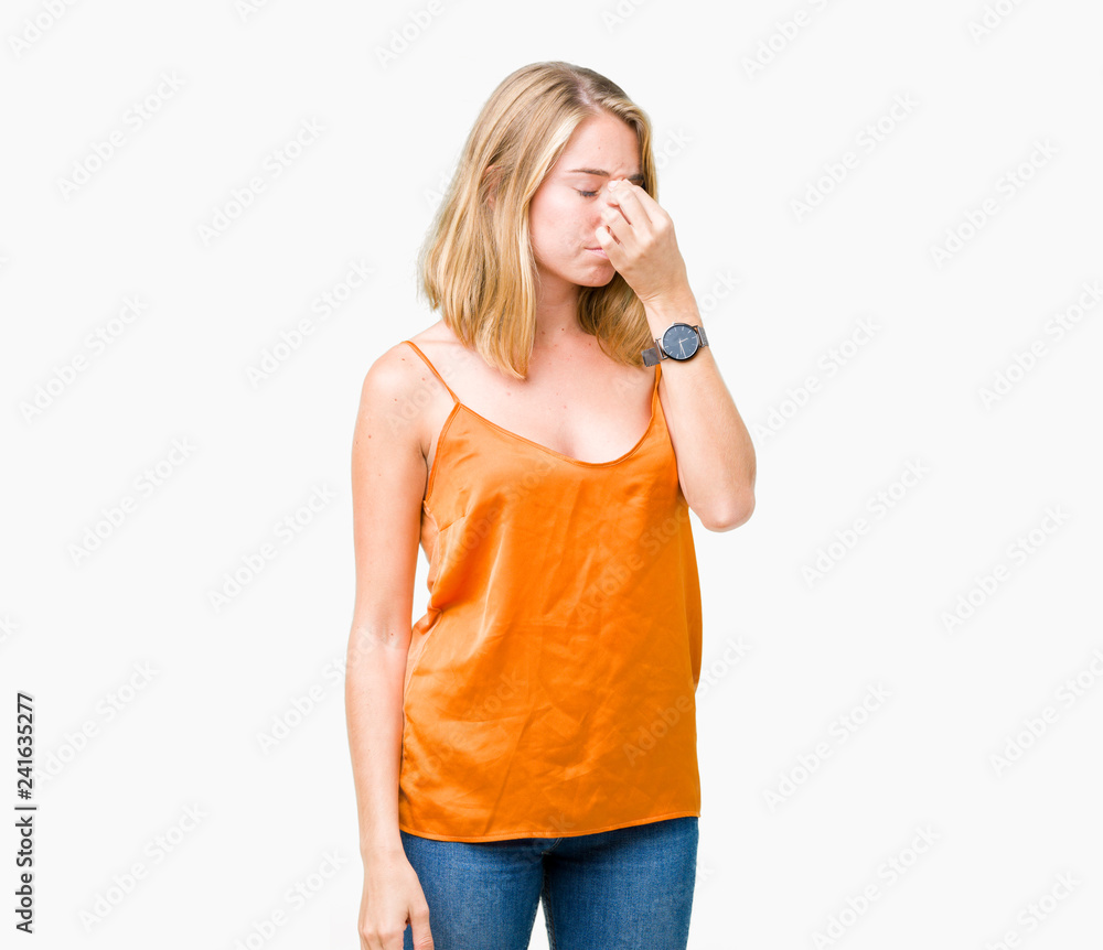 Beautiful young woman wearing orange shirt over isolated background tired rubbing nose and eyes feeling fatigue and headache. Stress and frustration concept. Beautiful young woman wearing orange shirt over isolated background tired rubbing nose and eyes feeling fatigue and headache. Stress and frustration concept.