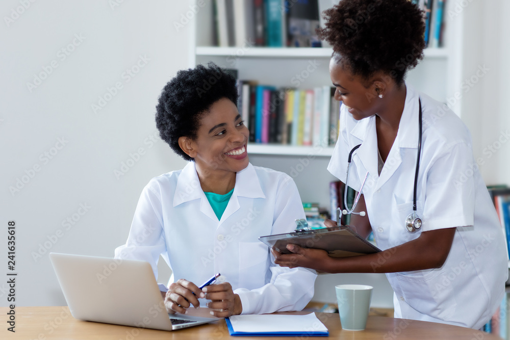 African american female doctor with young nurse African american female doctor with young nurse