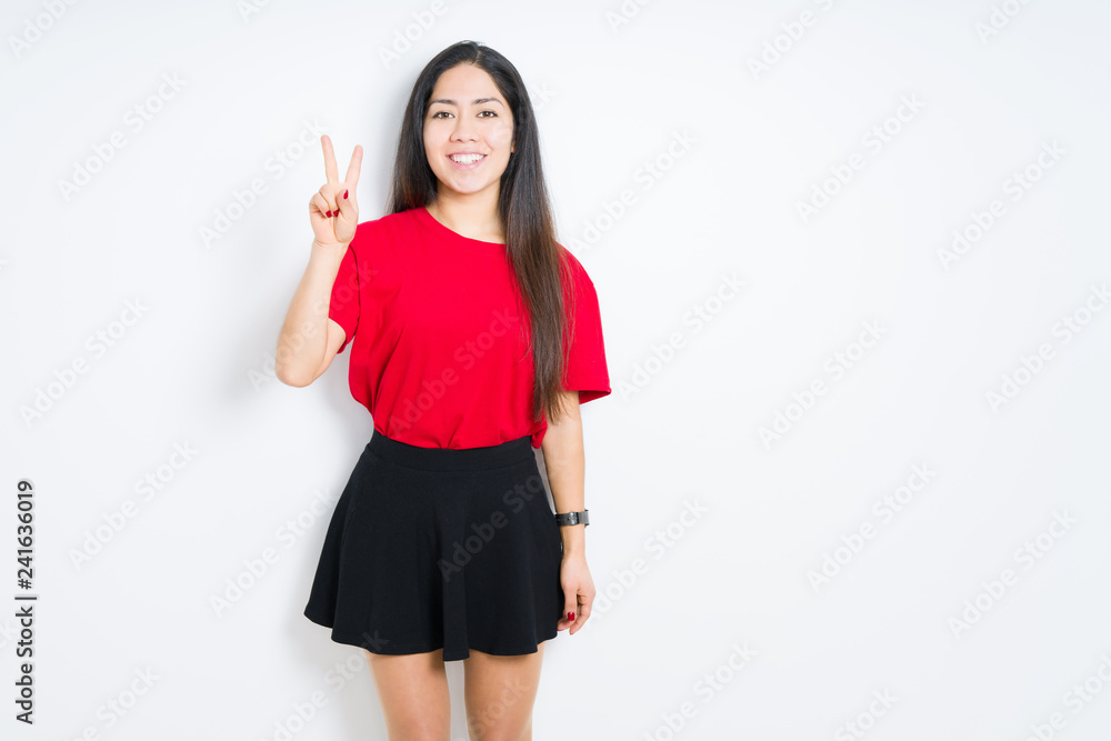 Beautiful brunette woman wearing red t-shirt and skirt over isolated background showing and pointing up with fingers number two while smiling confident and happy. Beautiful brunette woman wearing red t-shirt and skirt over isolated background showing and pointing up with fingers number two while smiling confident and happy.