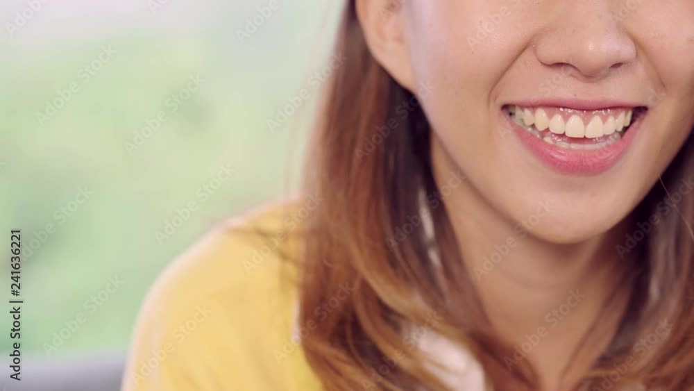 Teenager Asian woman feeling happy smiling and looking to camera while relax in her living room at home. Beautiful Asian young female using relax time at home concept. Teenager Asian woman feeling happy smiling and looking to camera while relax in her living room at home. Beautiful Asian young female using relax time at home concept.