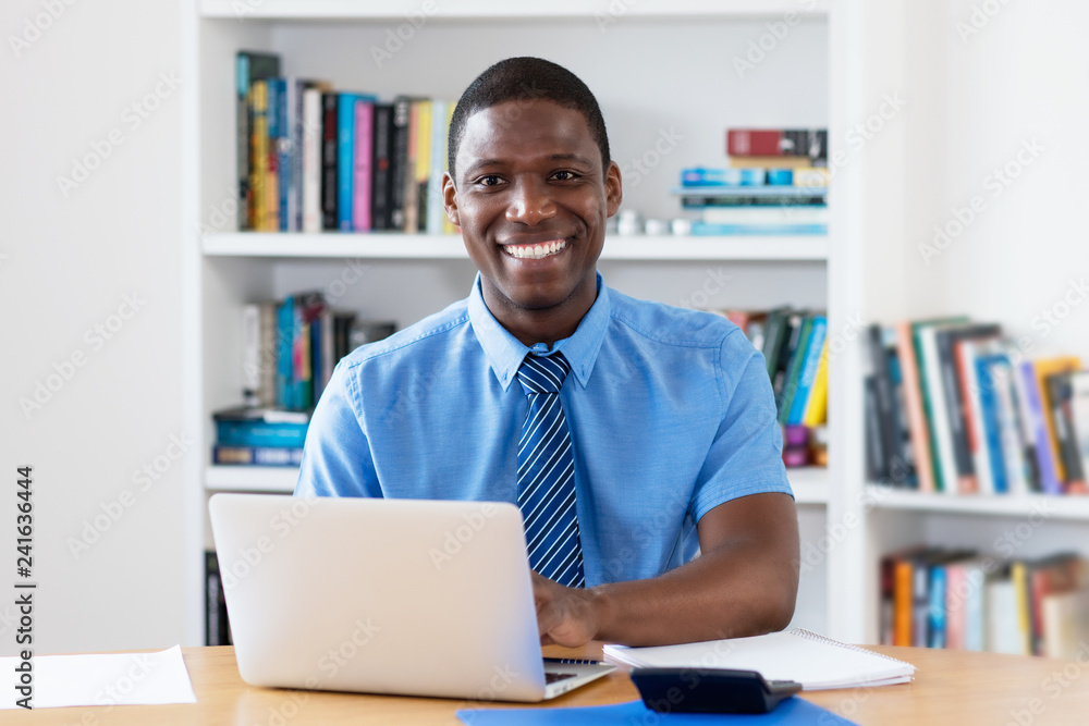 Laughing african american businessman with necktie at computer Laughing african american businessman with necktie at computer
