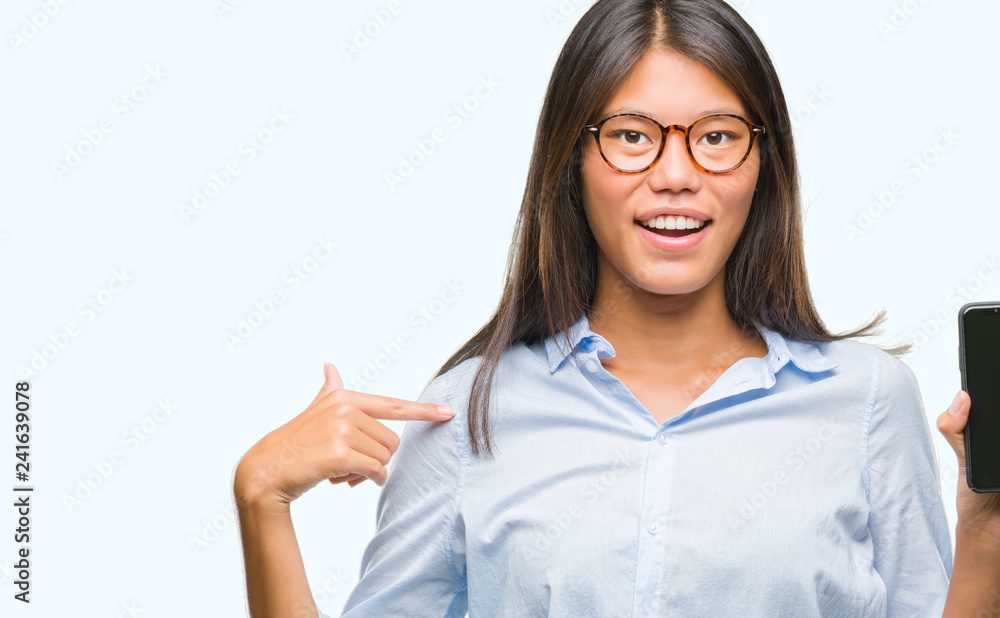 Young asian woman showing smartphone blank screen over isolated background with surprise face pointing finger to himself Young asian woman showing smartphone blank screen over isolated background with surprise face pointing finger to himself