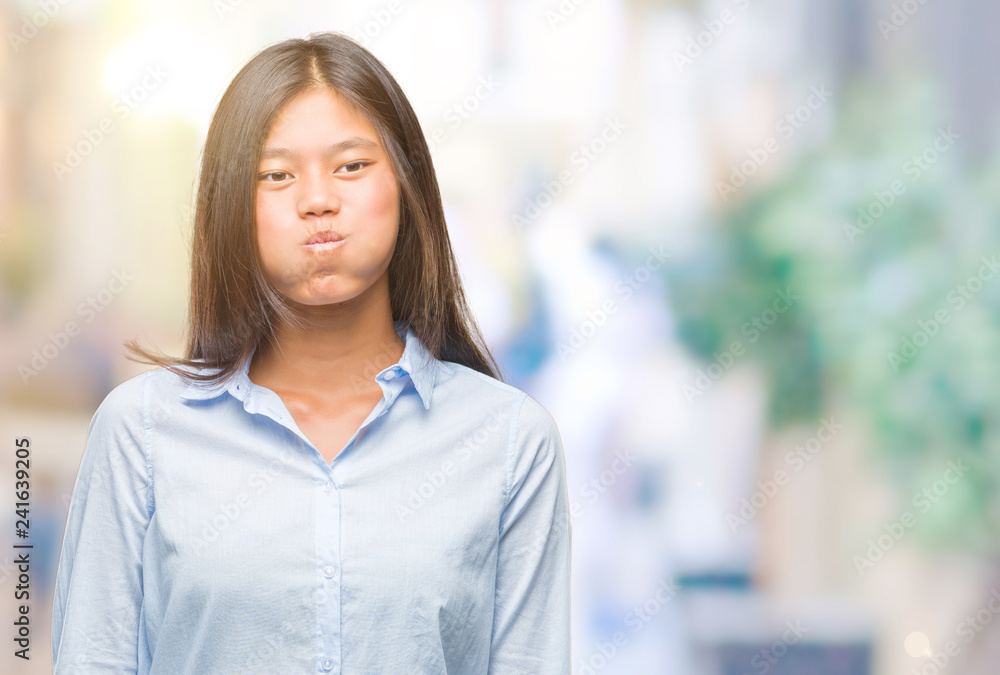 Young asian business woman over isolated background puffing cheeks with funny face. Mouth inflated with air, crazy expression. Young asian business woman over isolated background puffing cheeks with funny face. Mouth inflated with air, crazy expression.