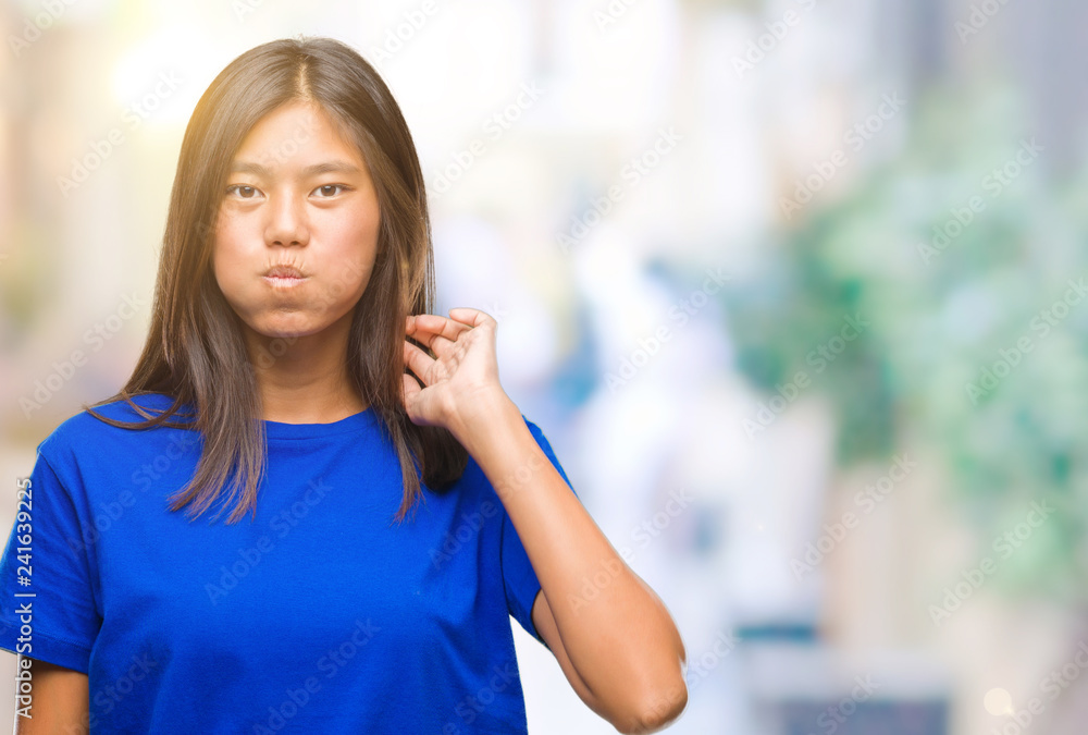 Young asian woman over isolated background puffing cheeks with funny face. Mouth inflated with air, crazy expression. Young asian woman over isolated background puffing cheeks with funny face. Mouth inflated with air, crazy expression.