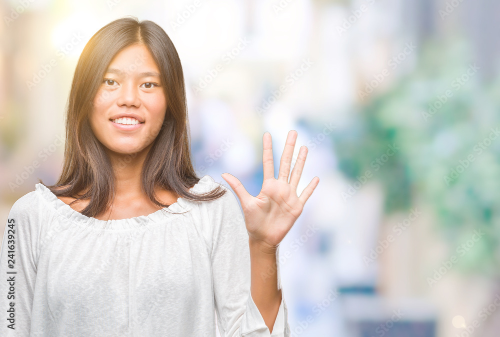 Young asian woman over isolated background showing and pointing up with fingers number five while smiling confident and happy.