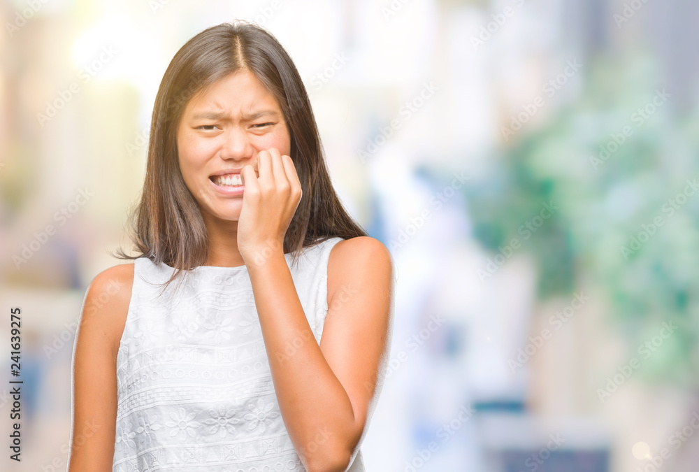 Young asian woman over isolated background looking stressed and nervous with hands on mouth biting nails. Anxiety problem. Young asian woman over isolated background looking stressed and nervous with hands on mouth biting nails. Anxiety problem.