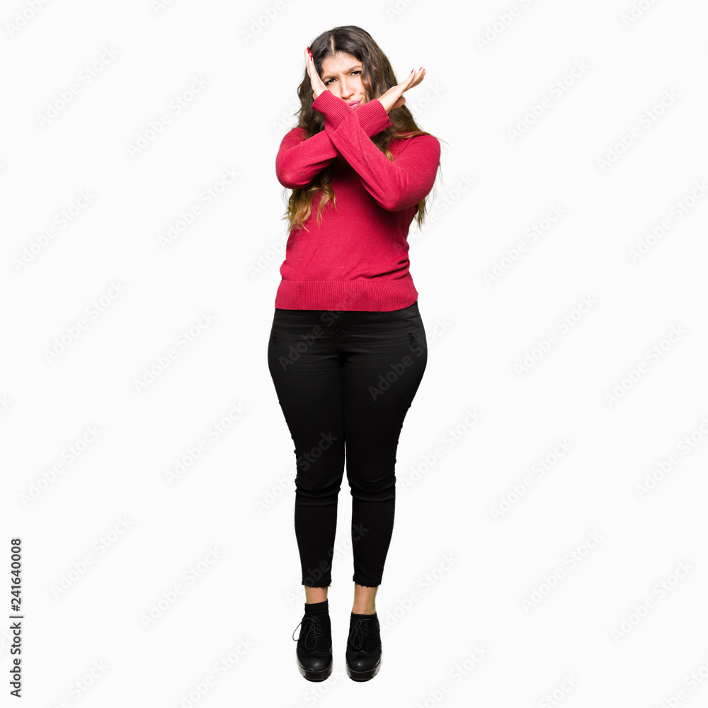 Fototapeta premium Young beautiful woman wearing red sweater Rejection expression crossing arms doing negative sign, angry face