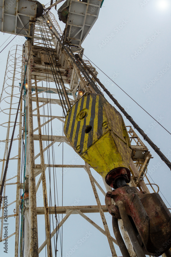 Fototapeta premium Oil and Gas Drilling Rig onshore dessert with dramatic cloudscape. Oil drilling rig operation on the oil platform in oil and gas industry. Land oil drilling rig blue sky