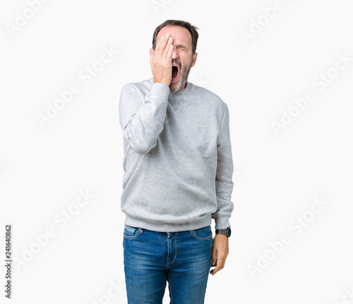 Handsome middle age senior man wearing a sweatshirt over isolated background Yawning tired covering half face, eye and mouth with hand. Face hurts in pain. © Krakenimages.com