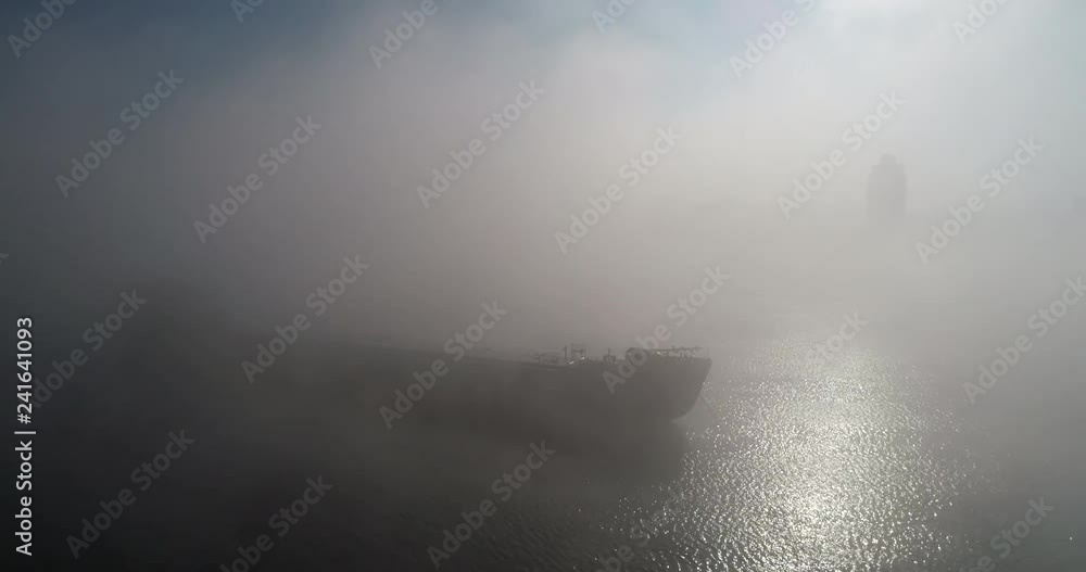 A huge barge on the river Dnipro in the morning fog with a visible silhouette of the buildings and city in the background (shot from the air) in 4K 7 A huge barge on the river Dnipro in the morning fog with a visible silhouette of the buildings and city in the background (shot from the air) in 4K 7
