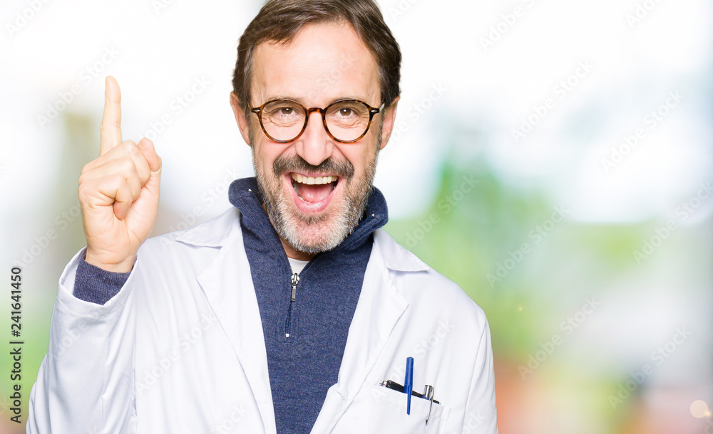 Middle age therapist wearing white coat pointing finger up with successful idea. Exited and happy. Number one. Middle age therapist wearing white coat pointing finger up with successful idea. Exited and happy. Number one.