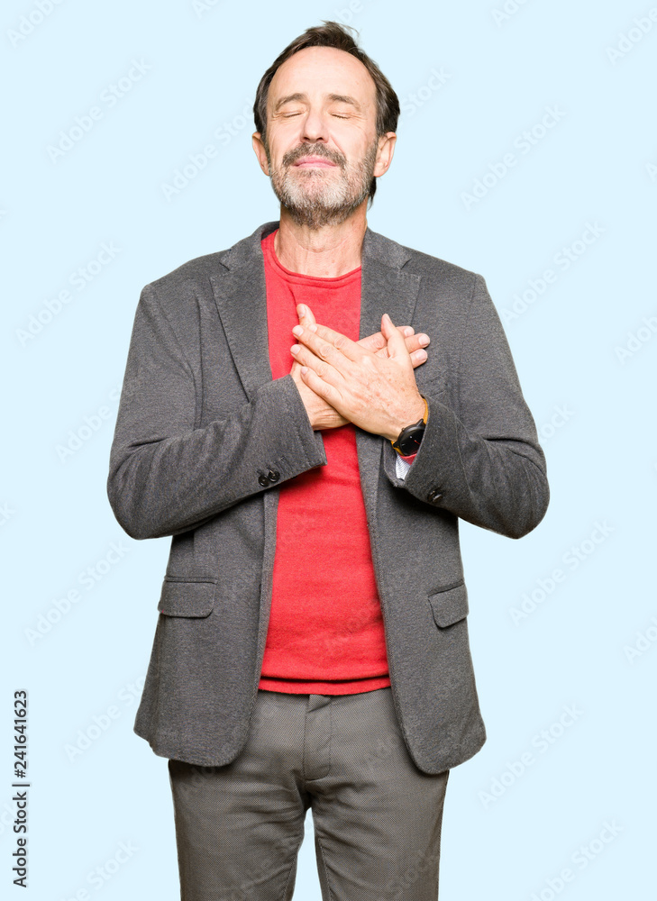 Middle age handsome business man smiling with hands on chest with closed eyes and grateful gesture on face. Health concept. Middle age handsome business man smiling with hands on chest with closed eyes and grateful gesture on face. Health concept.