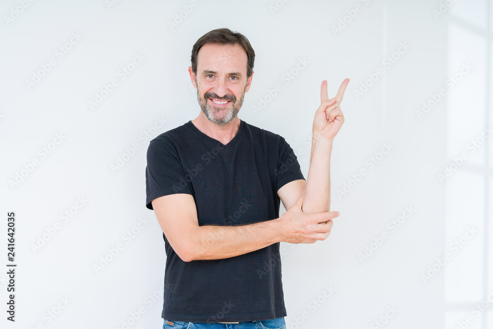 Senior man over isolated background smiling with happy face winking at the camera doing victory sign. Number two. Senior man over isolated background smiling with happy face winking at the camera doing victory sign. Number two.