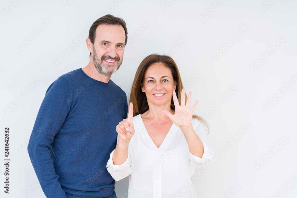 Beautiful middle age couple in love over isolated background showing and pointing up with fingers number six while smiling confident and happy.