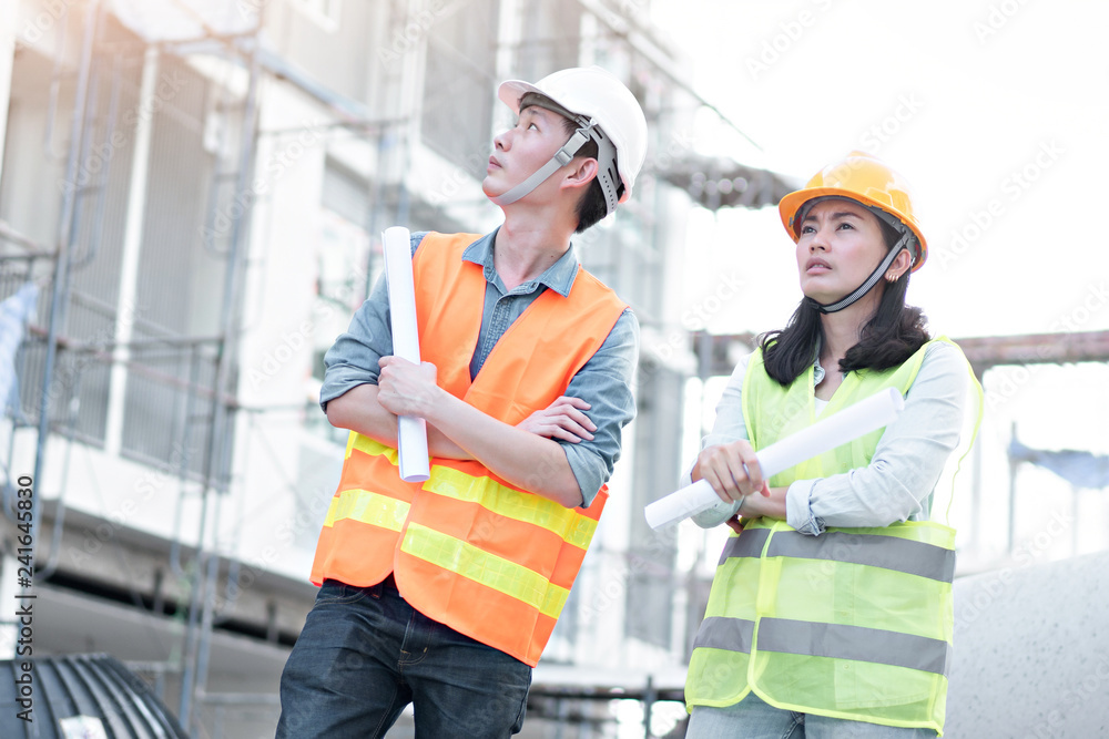 Team of engineers wearing yellow helmet and working at construction site Team of engineers wearing yellow helmet and working at construction site