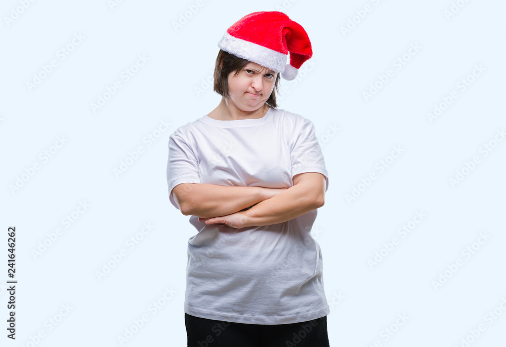 Young adult woman with down syndrome wearing christmas hat over isolated background skeptic and nervous, disapproving expression on face with crossed arms. Negative person.