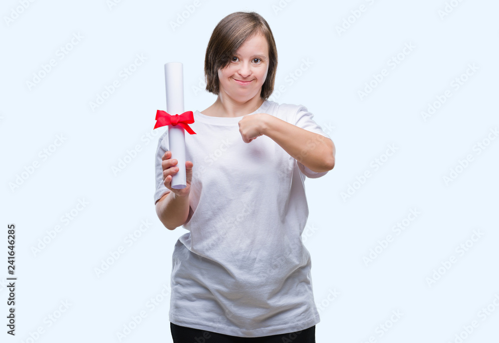 Young adult woman with down syndrome holding degree over isolated background with surprise face pointing finger to himself Young adult woman with down syndrome holding degree over isolated background with surprise face pointing finger to himself