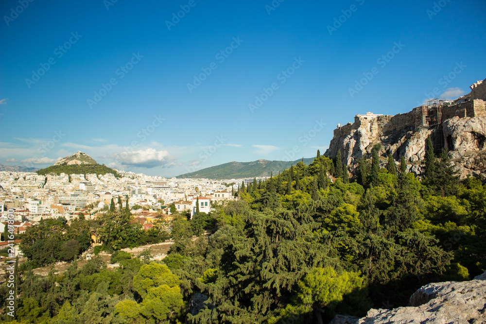 park outdoor and rock with construction in south European city view with many buildings and lonely mountain on background 