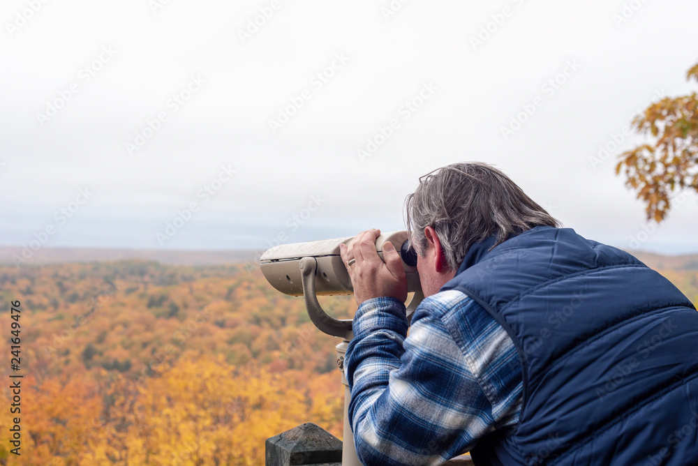 Middle-aged man using binoculars at state park