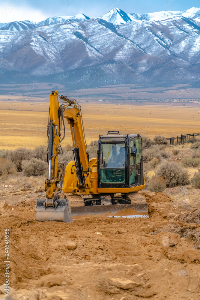 Obraz premium Tractor in front of wonderful mountains behind