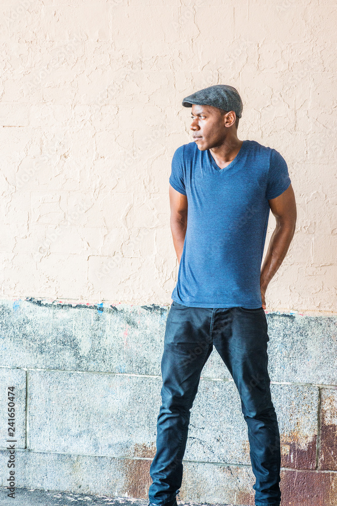 Young African American Man York, wearing blue V neck T shirt, flat cap, black