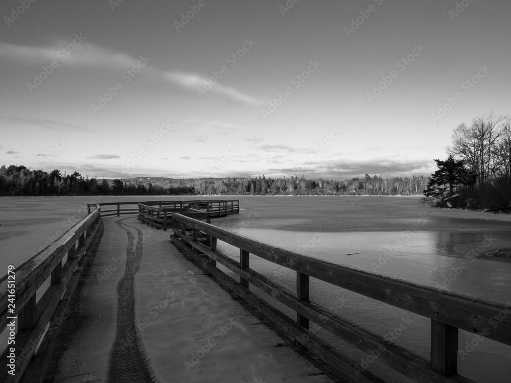 pier at sunset on lake in winter black and white