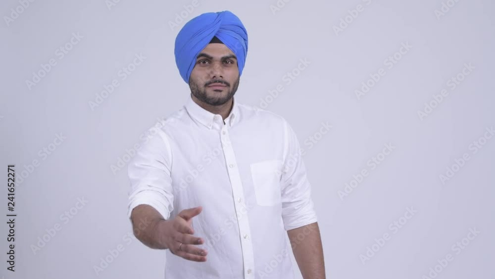 Young bearded Indian Sikh man giving handshake Young bearded Indian Sikh man giving handshake