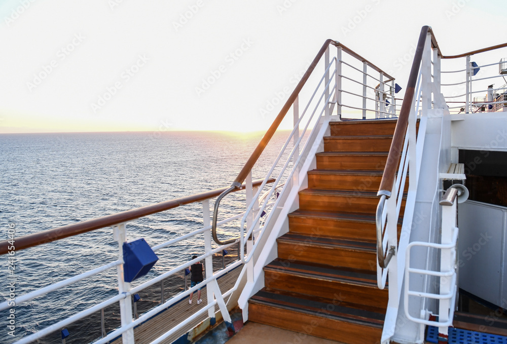 Obraz premium Railing and stairs of a cruise ship at sunset.