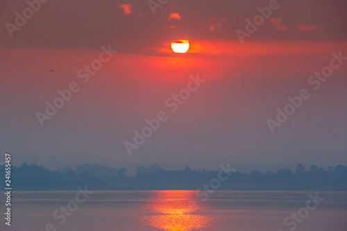 Sun rise over big lake of Bangpra Reservoir, the famous place in Chonburi Thailand, Orange color Tone photo